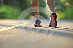 woman legs running at morning tropical forest trail