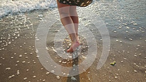 Woman legs in sea water. Carefree happy girl enjoys summer at the beach, jumping at seaside. Travel, vacation, summer concept