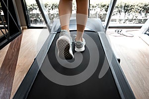 Woman legs with sport shoes running on treadmill in fitness gym