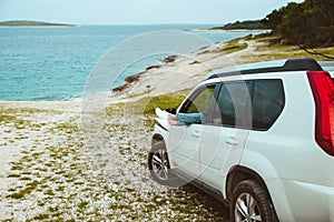 woman legs stick out from car parked at sea beach