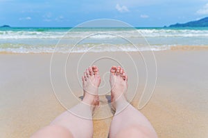 Woman legs sunbathing near the beach during travel holidays vacation outdoors at ocean or nature sea at noon, Phuket, Thailand