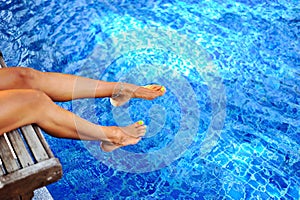 Woman legs in a swimming pool. Vocation & Relax