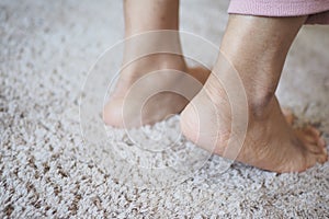 Woman legs tip toeing barefoot on a cart at home .