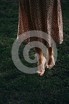 Woman legs tip toeing on dark green grass