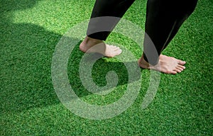 Woman legs walking on green grass