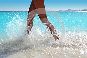 Woman legs walking splashing beach aqua water