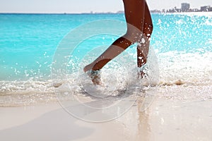 Woman legs walking splashing beach aqua water