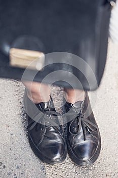 Woman legs wearing black shoes on the street