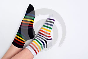 Woman legs wearing funny bright different striped colorful socks on white background with copy space. Flat lay