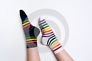 Woman legs wearing funny bright different striped colorful socks on white background with copy space. Flat lay