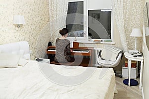 Woman in leopard print dress plays on synthesizer photo