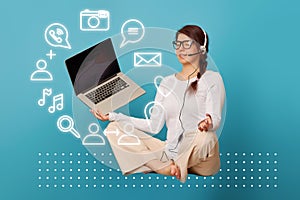 Woman levitates in lotus position with laptop.