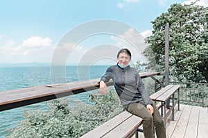 Woman (LGBTQ) posing at sea viewpoint with happy