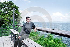 Woman (LGBTQ) posing at sea viewpoint with happy