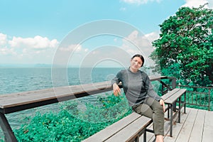 Woman (LGBTQ) posing at sea viewpoint with happy