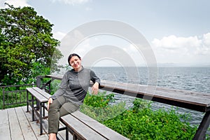 Woman (LGBTQ) posing at sea viewpoint with happy