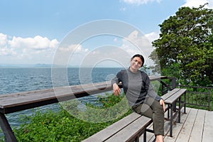 Woman (LGBTQ) posing at sea viewpoint with happy