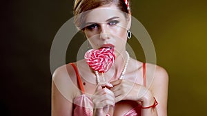 Woman lick lollipop confection and dance seductive