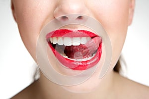 Woman licking teeth with tongue