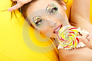 Woman licks candy with beautiful make-up