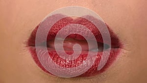 Woman licks his lips with red lipstick