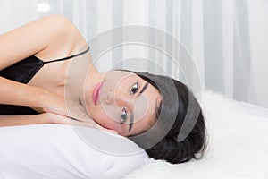 woman lie down on the bed looking to camera.