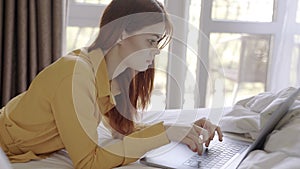 woman lies in bed in front of laptop communication leisure technology