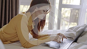 woman lies in bed in front of laptop communication leisure technology