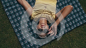 a woman lies on a blanket on the lawn