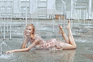 Woman lies in a city fountain.