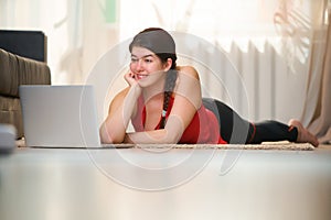 Woman lies on the floor and chating via laptop