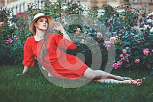 Woman lies on the grass among flowers.