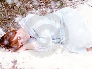 Woman lies in the snow. Sleeping woman in a snowy forest. Fairytale image