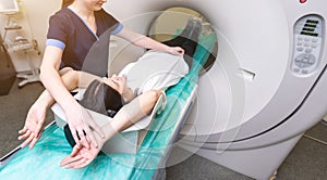 A woman lies on the tomograph table. woman is undergoing computed axial tomography examination in a modern hospital