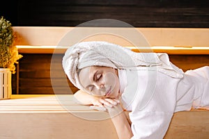 Woman lies warming herself in sauna. Detox program spa skin care.