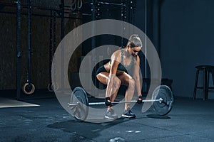 Woman lifting barbell at gym