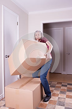 Woman lifting a big box in a house