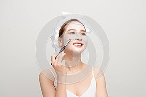 Woman with lifting cream applied on her face, isolated on white