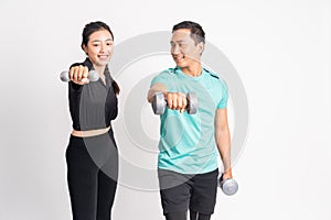 woman lifting dumbbells and man guiding by lifting dumbbells also