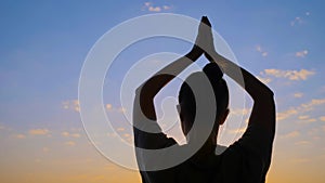 Woman is lifting hands up, doing stretching exercises - sun salutation, yoga