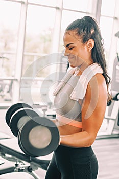 Woman lifting weights dumbbells action of lift captured.