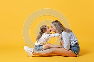 Woman in light clothes have fun with cute child baby girl 4-5 years old. Mommy little kid daughter isolated on yellow