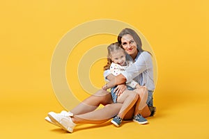 Woman in light clothes have fun with cute child baby girl 4-5 years old. Mommy little kid daughter  on yellow