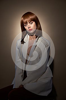 Woman in light coat gesticulate with hands studio