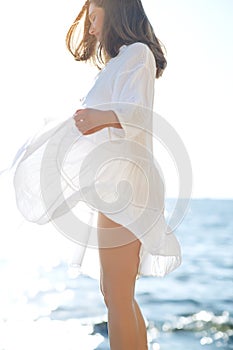 A woman in a light dress in nature, beautifully fluttering hair, soft sunset light.