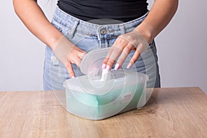 Woman with light pink nails taking wet wipes from the disposable package - hygiene procedure and prevention of infectious diseases