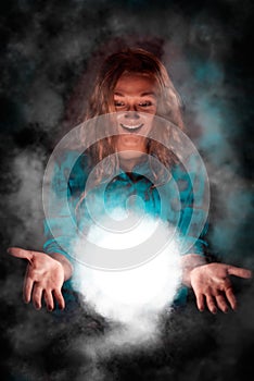 Woman with light sphere between her palms, spiritual energy