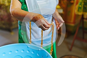 Woman lighting candles on a Baptismal font in the Orthodox Church.