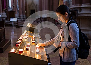 Woman lighting candles in church