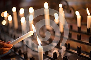 Woman lighting prayer candle